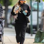Kaley Cuoco in a Black Cap Walks Her Dog in New York
