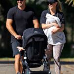 Jennifer Hawkins in a Black Cap Walks with Her Husband Jake Wall and Children in Sydney
