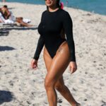 Chaney Jones in a Black Swimsuit on the Beach in Miami