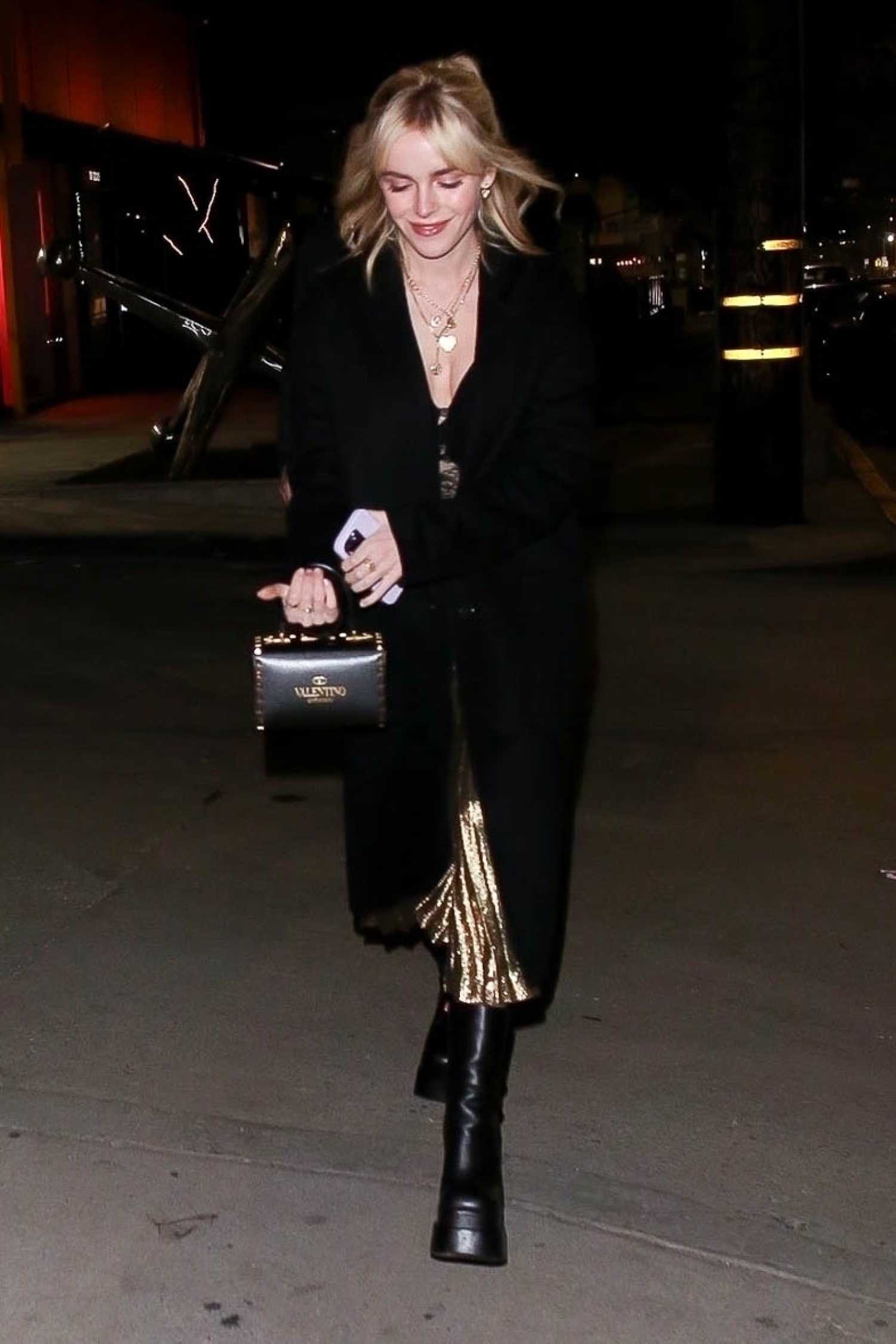 Kiernan Shipka in a Black Coat Arrives at Leonardo DiCaprio’s Holiday