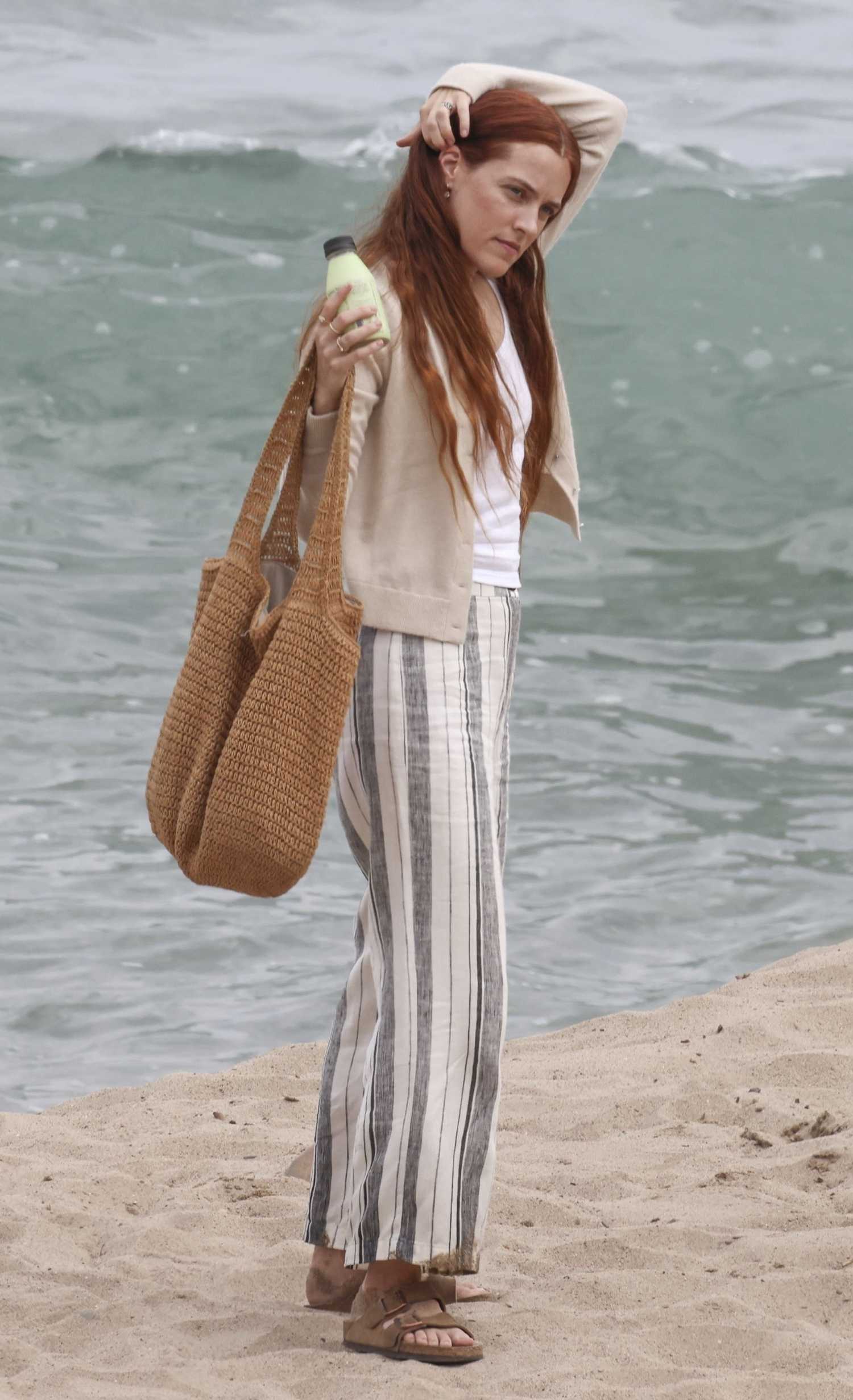 Riley Keough in a Beige Cardigan Filming a Commercial in Malibu – Celeb