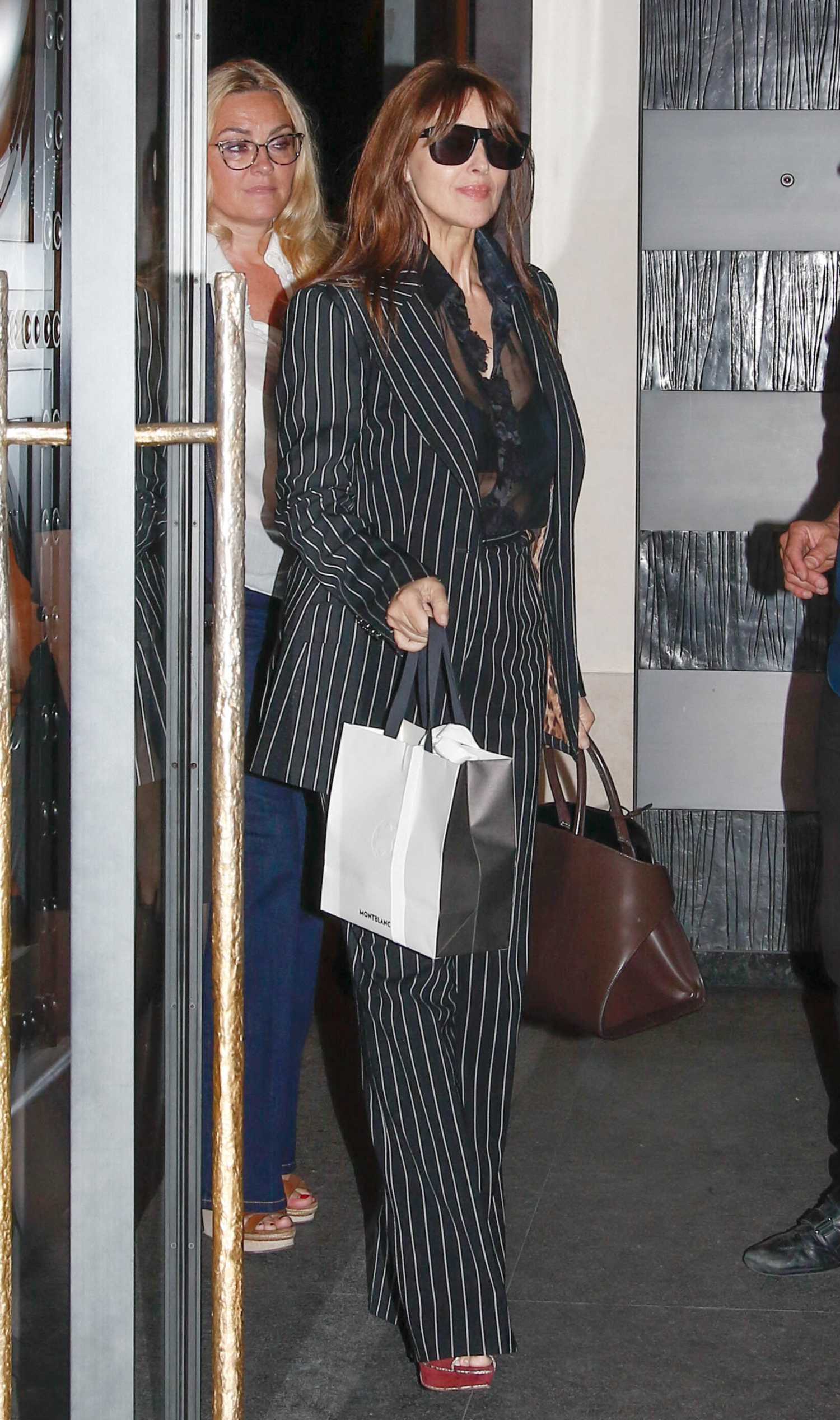 Monica Bellucci in a Black Striped Pantsuit Leaves Costes Restaurant in