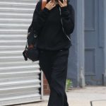 Irina Shayk in a Black Sweatsuit Engages in an Animated Phone Conversation in New York